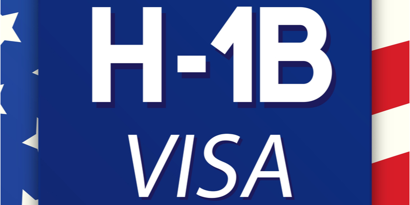 On a background with an American flag, the text H1B - VISA is written in a bold white font.