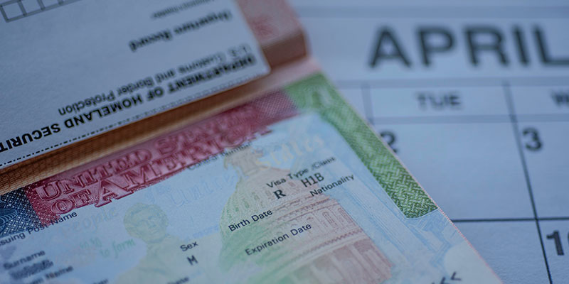 Close up view of the United States of America H1B Visa,blurred April month calendar in the background