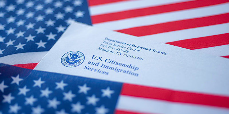 An official letter from the US Department of Homeland Security with its logo and the text "US Citizenship and Immigration Services" covered in flags of the United States