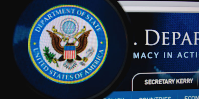 Blurred image of U.S. Department of State homepage on a computer monitor.